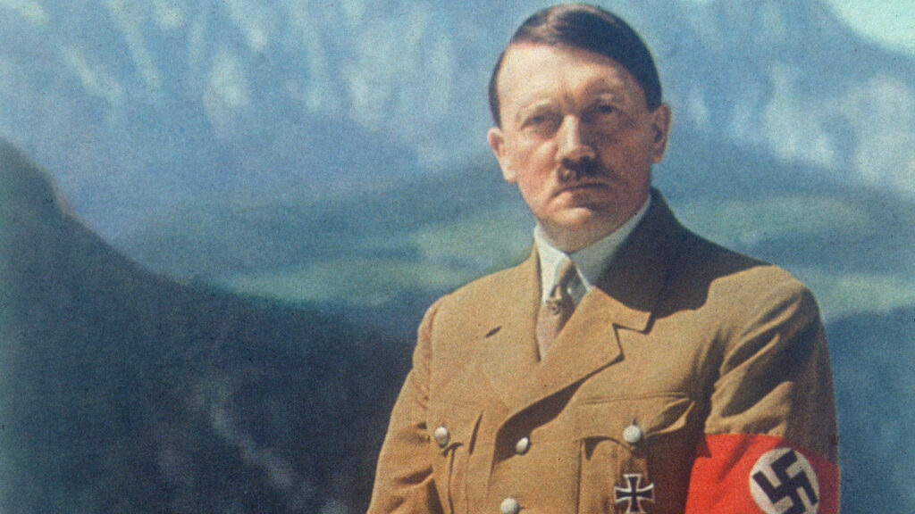 Hitler em foto colorida tem atrás dele cadeias de montanhas nevadas.