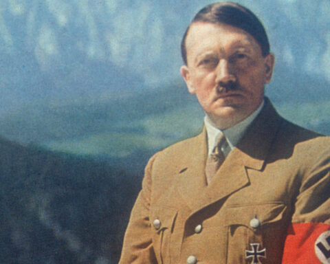 Hitler em foto colorida tem atrás dele cadeias de montanhas nevadas.