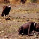 Foto "o abutre e a menina", de Kervin Carter. Uma menina negra de 3 anos aproximadamente está agachada, muito magra, enquanto um urubu a observa.