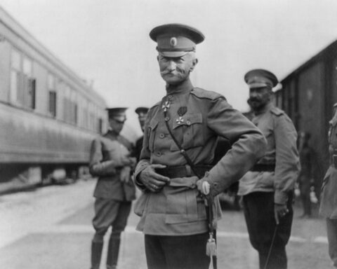 Aleksei Brusilov em foto preto e branca olha para frente, com as mãos na cintura, enquanto, atrás dele, seus comandados.