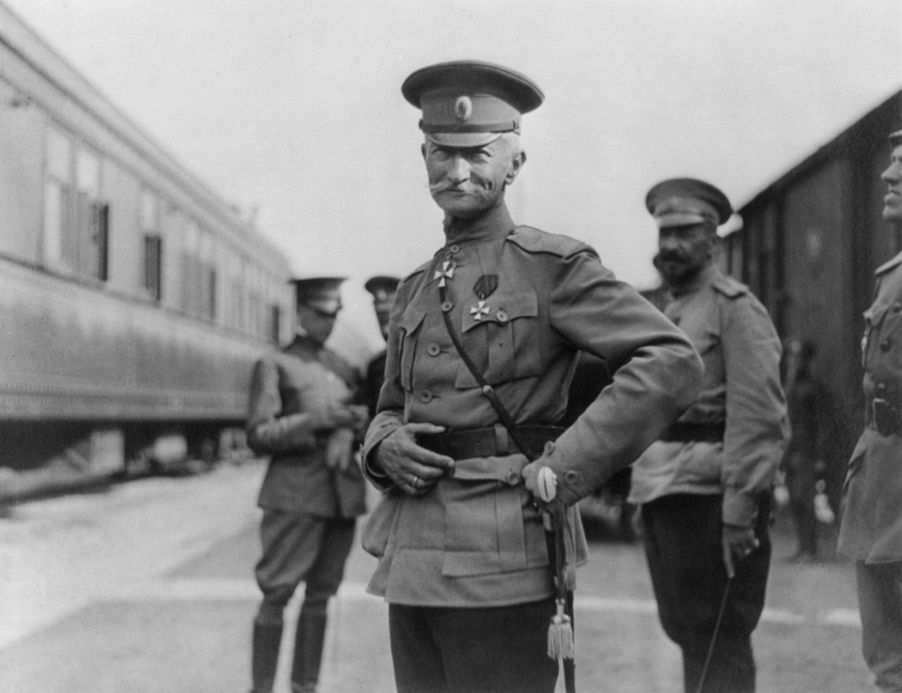 Aleksei Brusilov em foto preto e branca olha para frente, com as mãos na cintura, enquanto, atrás dele, seus comandados.