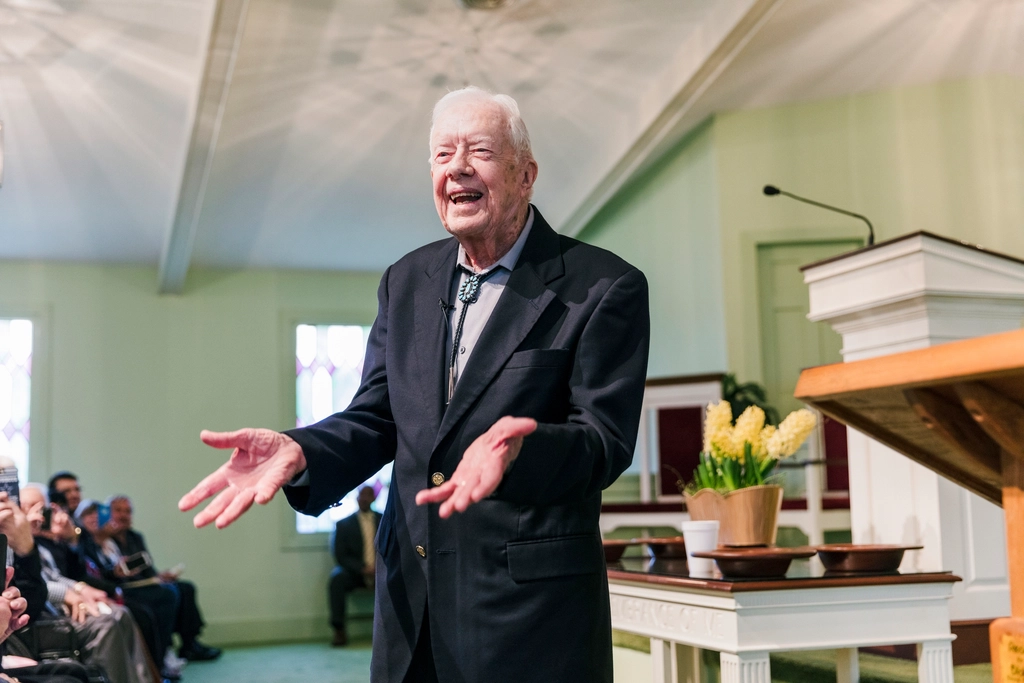 O ex-presidente Jimmy Carter, aos 100 anos, aparece rindo em uma convenção política. 