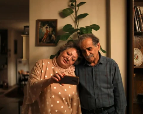 Protagonistas estão um ao lado do outro dentro de casa tirando uma foto no celular, cena bonita de Meu bolo favorito.