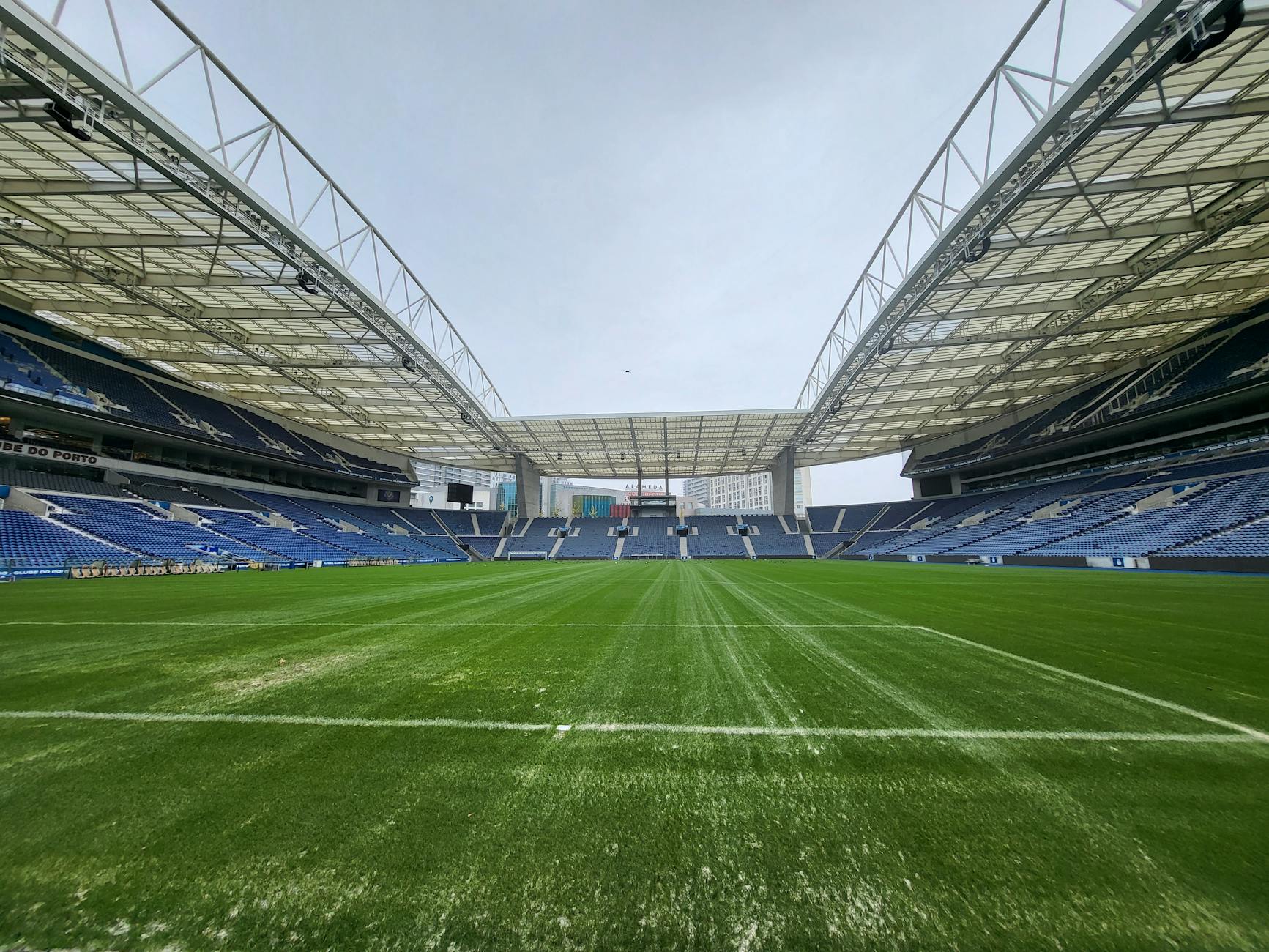 Estádio de futebol vazio. Céu azul, grama verda. Cenário provável de "Jogo da Corrupção".