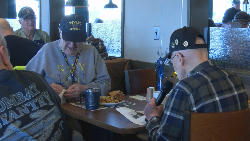 Lester Weko e Mike Heilmann sentados tomando café no restaurante. Veteranos da Segunda Guerra Mundial de 100 anos de idade.