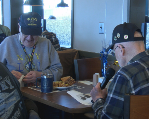 Lester Weko e Mike Heilmann sentados tomando café no restaurante. Veteranos da Segunda Guerra Mundial de 100 anos de idade.