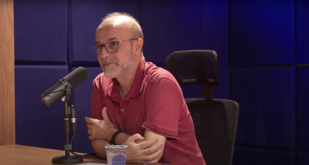 Marco Napolitano, de camisa vermelha, no estúdio, comenta Ainda estou aqui.